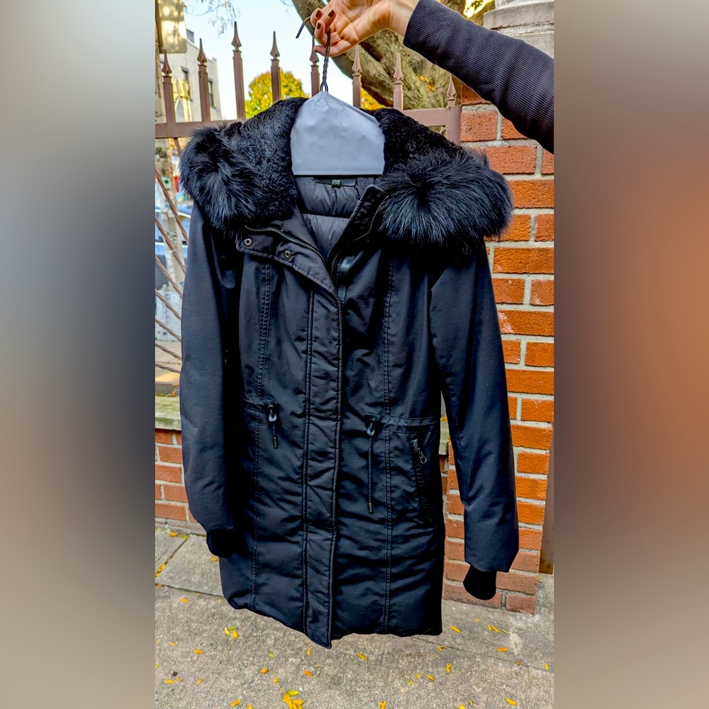 Black Knee-length Mackage down coat with fur hood and leather details.